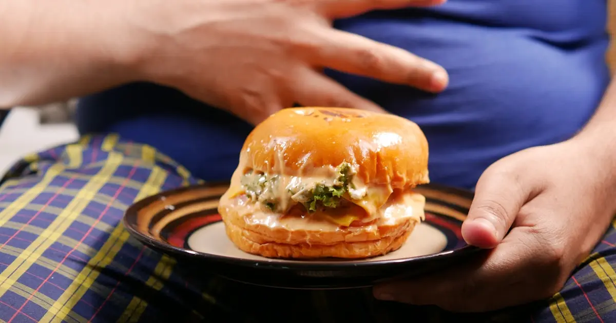 товста людина з гамбургером