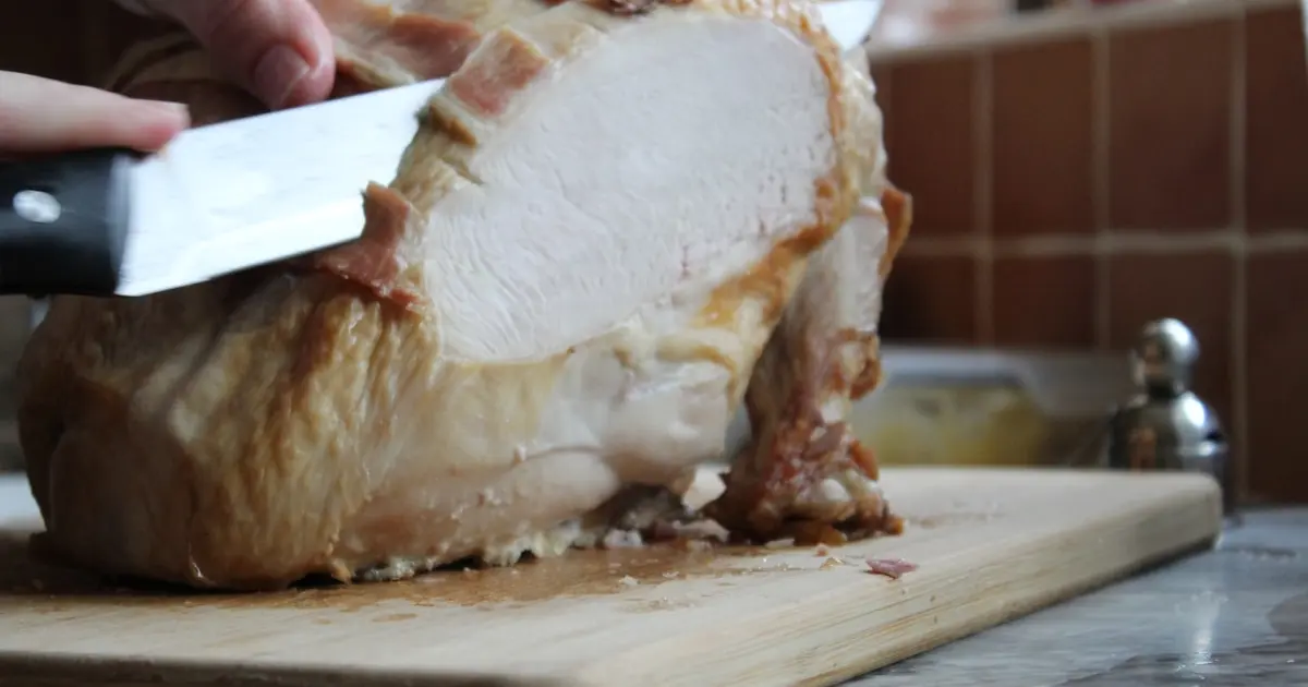 людина нарізає індичку