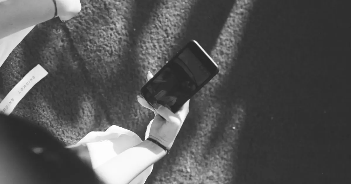 жінка стоїть зі смартфоном у руці