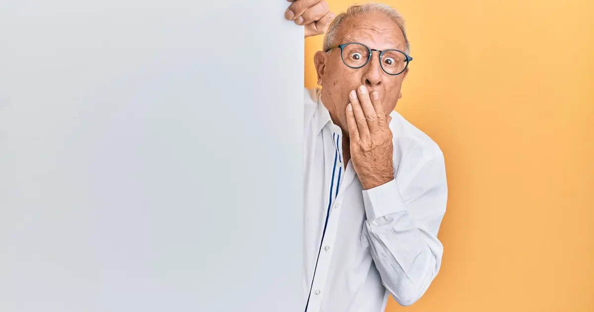 переляканий чоловік виглядає з-за стіни