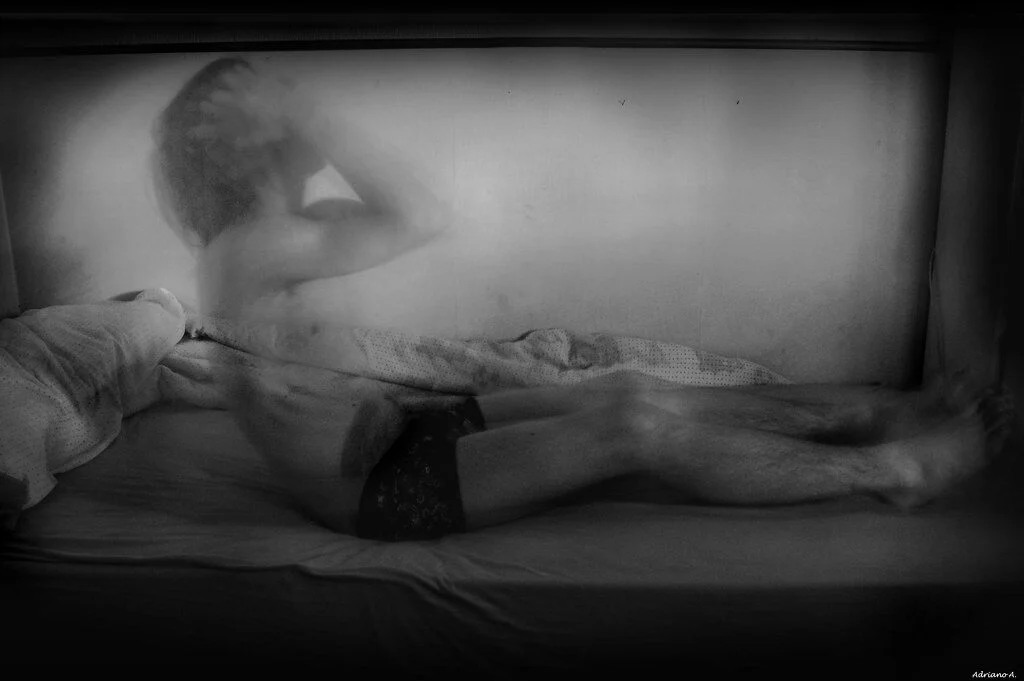 людина у ліжку тримається за голову